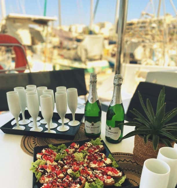 Panormo: Sunset All-Inclusive Catamaran Cruise with Snacks - Getting on board: Panormo port, DanEri flag, and optional transfers
